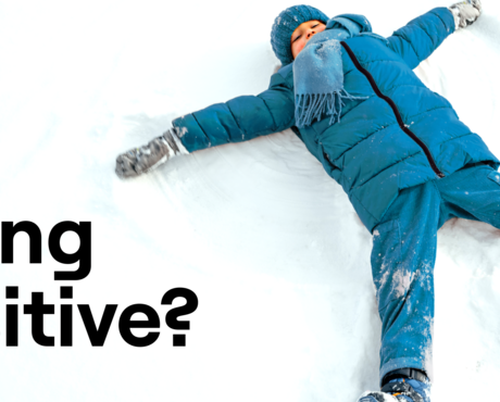 Child in snow making a snow angel.