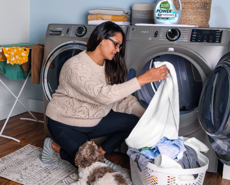 Woman loading clothes in washing machine