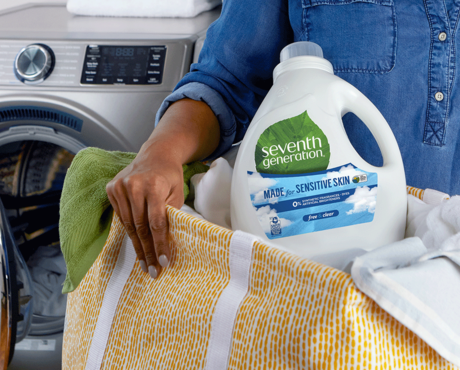 Woman holding laundry detergent in a basket