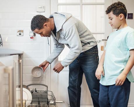 Image of caretaker and child loading dishwasher